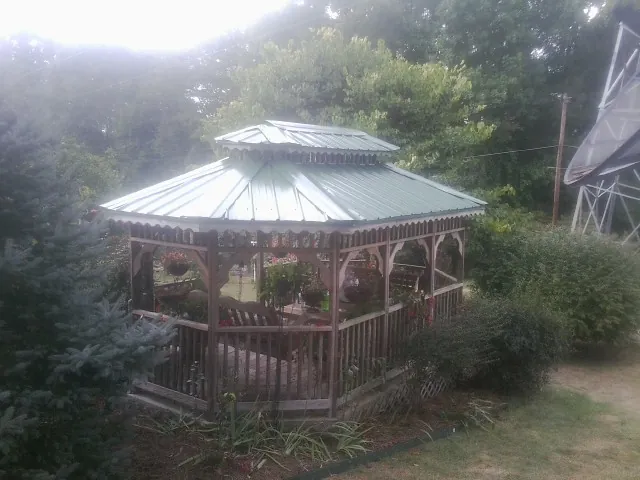 Green metal roof on a backyard gazebo surrounded by garden beds in Washington